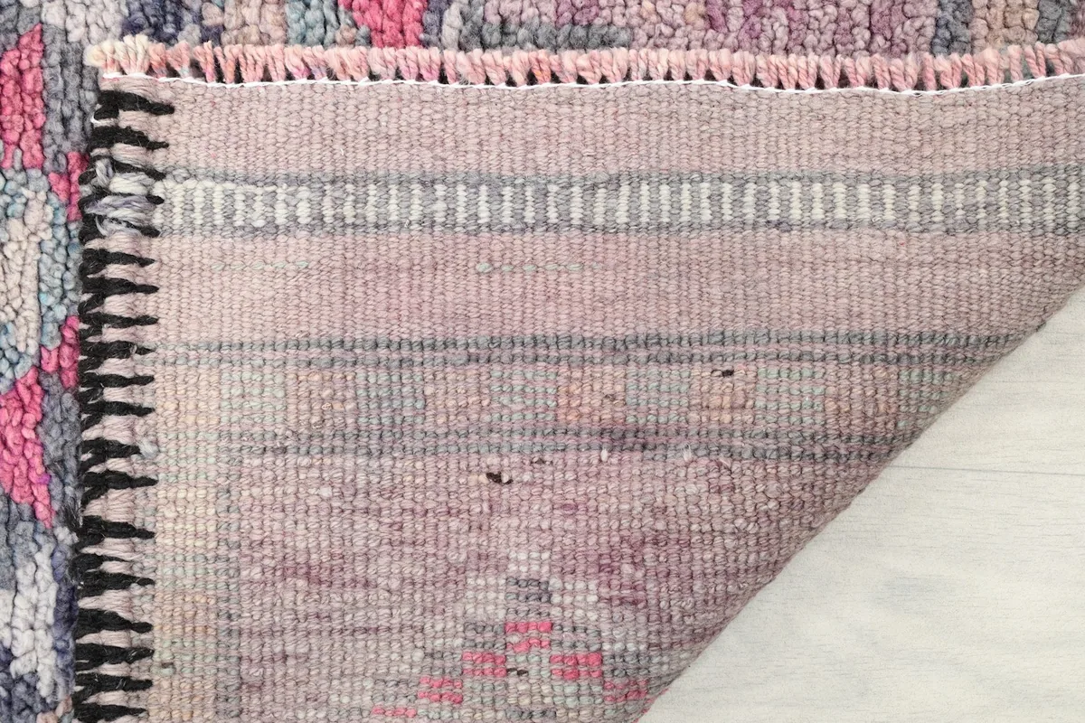 Close-up of the low wool pile and the reverse side of the rug, showing its structure