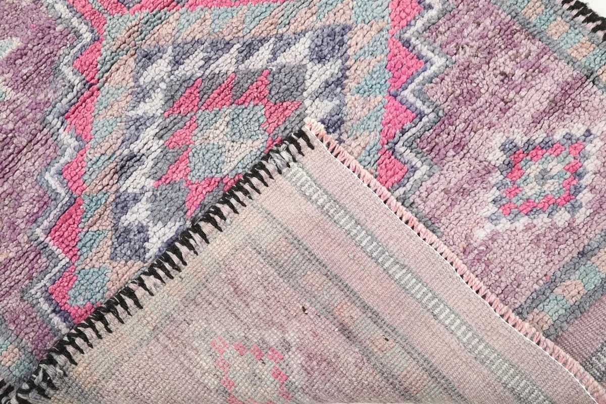 View of the back of the rug, revealing the intricate hand-knotted construction and cotton foundation