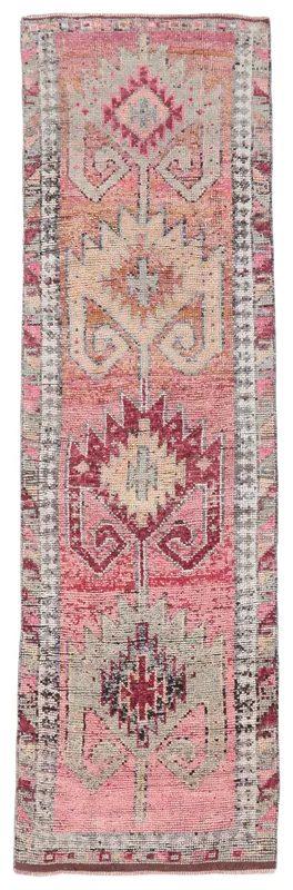 Full overhead view of the vintage Anatolian runner rug with rose, beige, and gray geometric patterns.