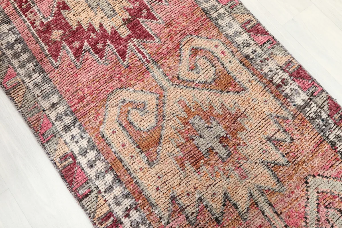Close-up of the rug's central design, highlighting the tribal motifs and color variations.