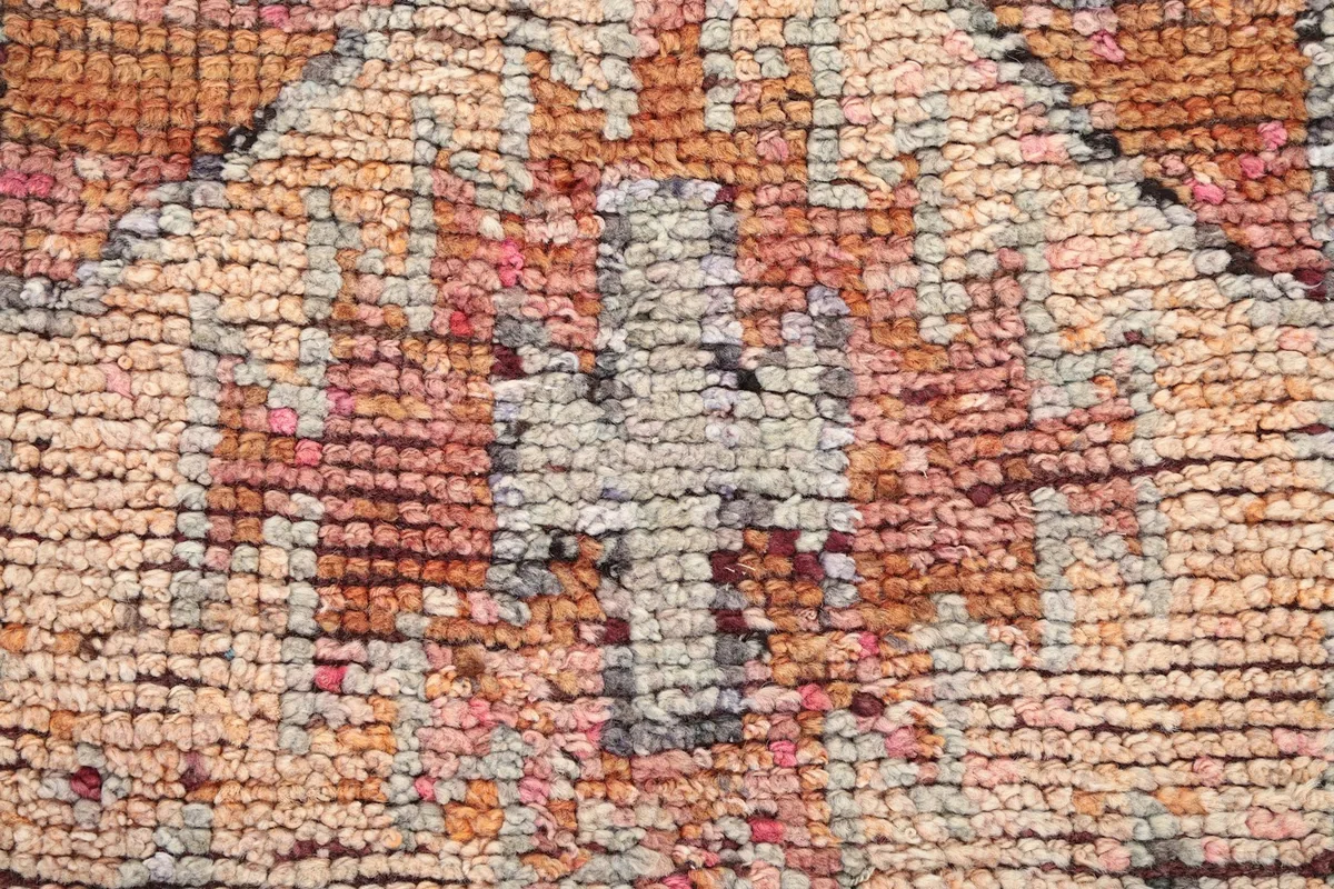 Extreme close-up of the hand-knotted wool pile, showing individual knots and texture.