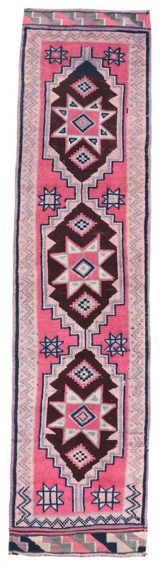 Full overhead view of the pink tribal Anatolian runner rug on a white background