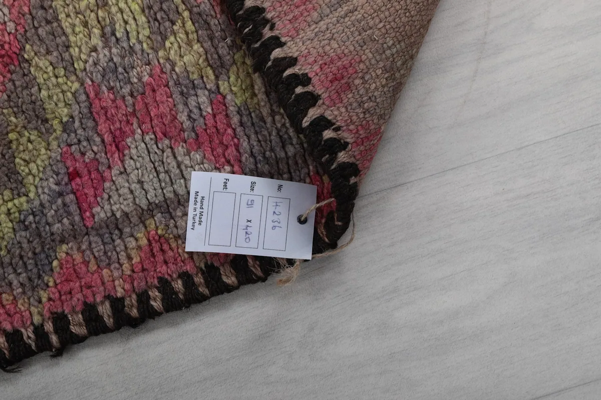 Corner of the rug with a product tag showing size and material details