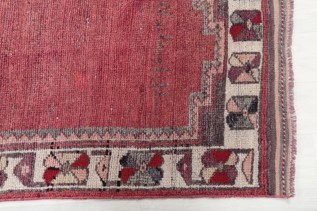Detailed view of the rose field and the geometric border pattern of the rug
