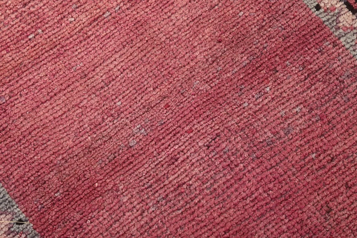 Close-up texture of the hand-knotted wool pile in the rose field