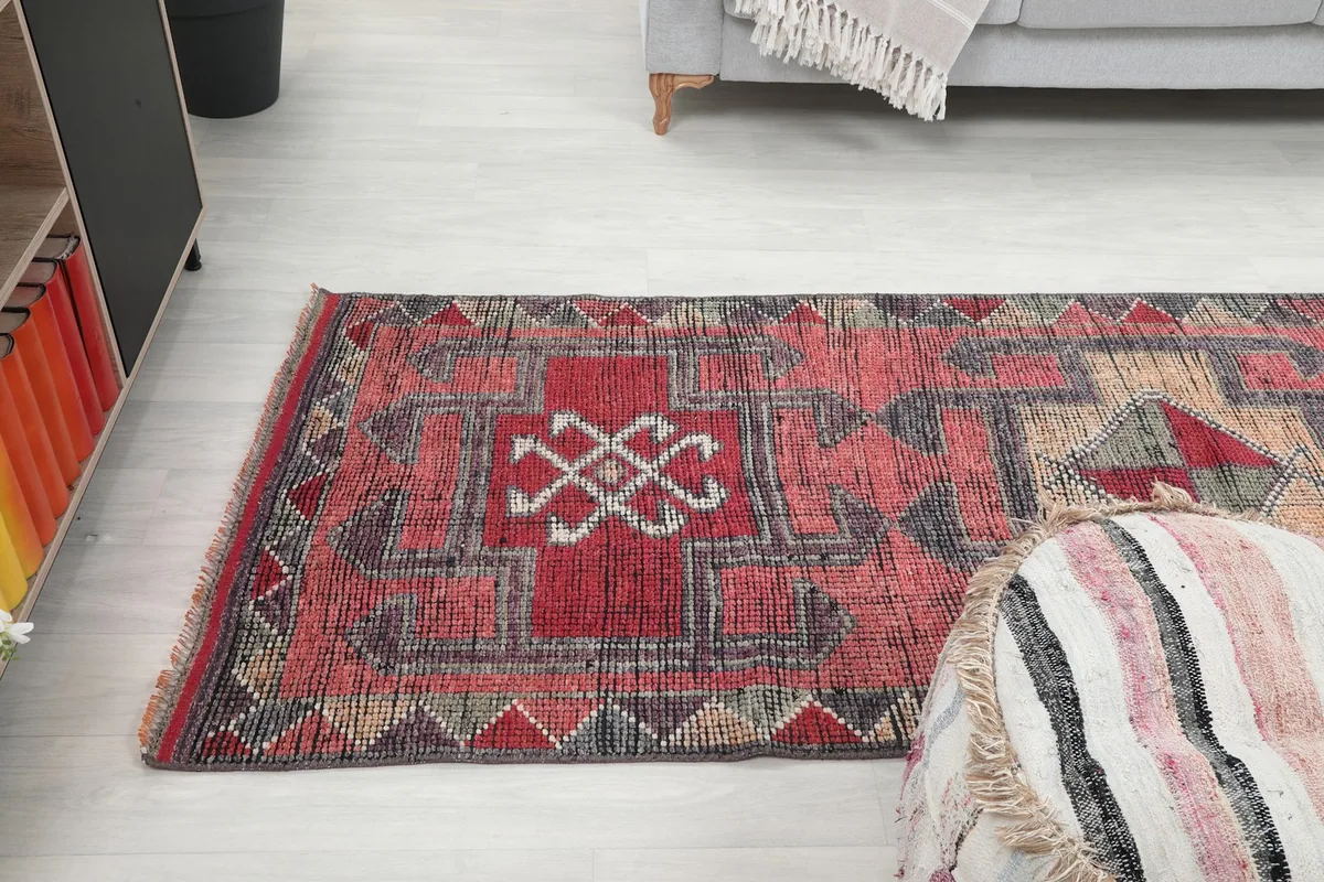 Angled view of the runner rug showing its length and design next to a sofa