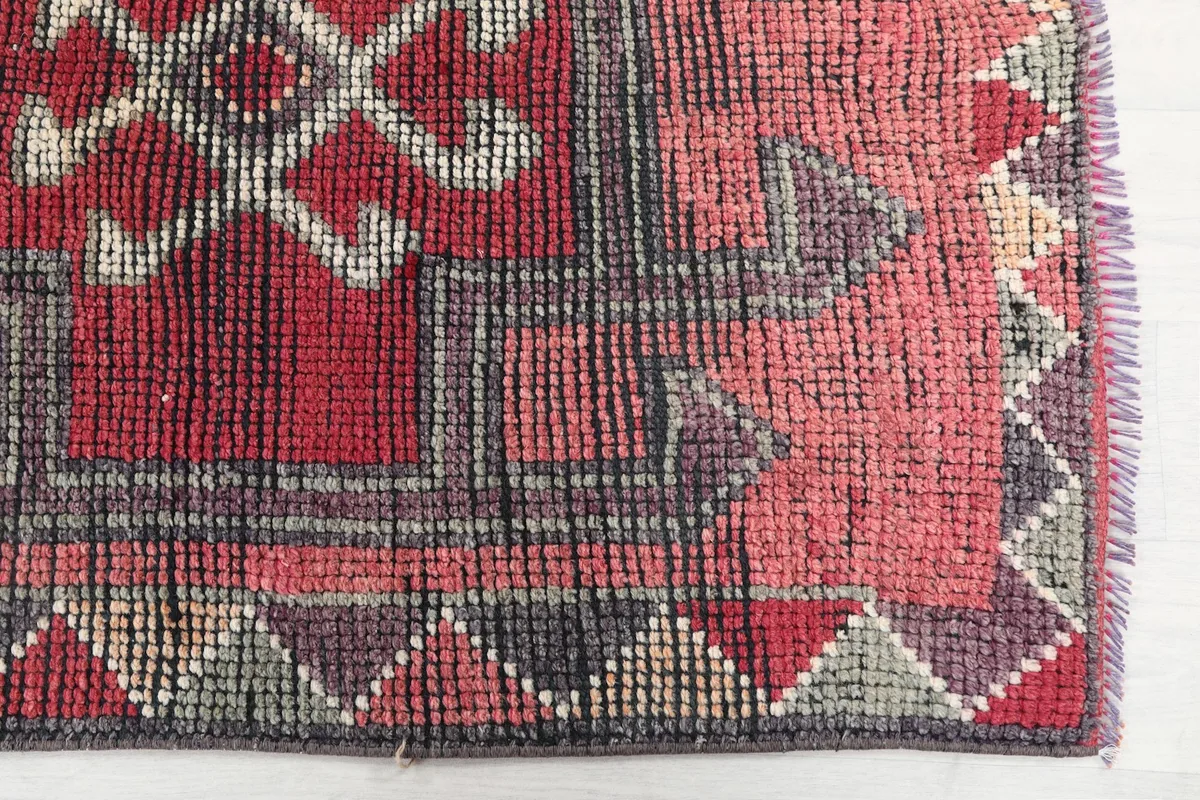 Close-up detail of the rug's border and corner with geometric patterns