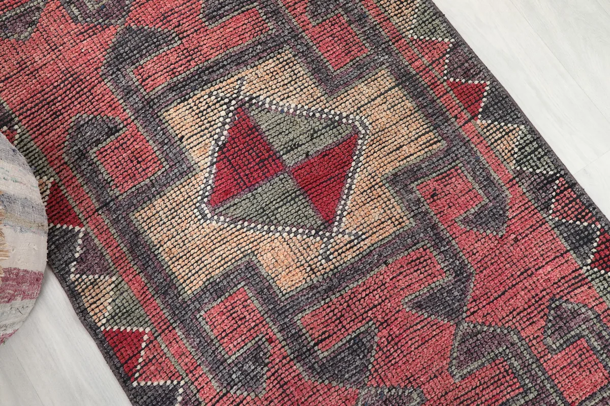 Close-up of the central geometric medallion and surrounding patterns in rust and charcoal