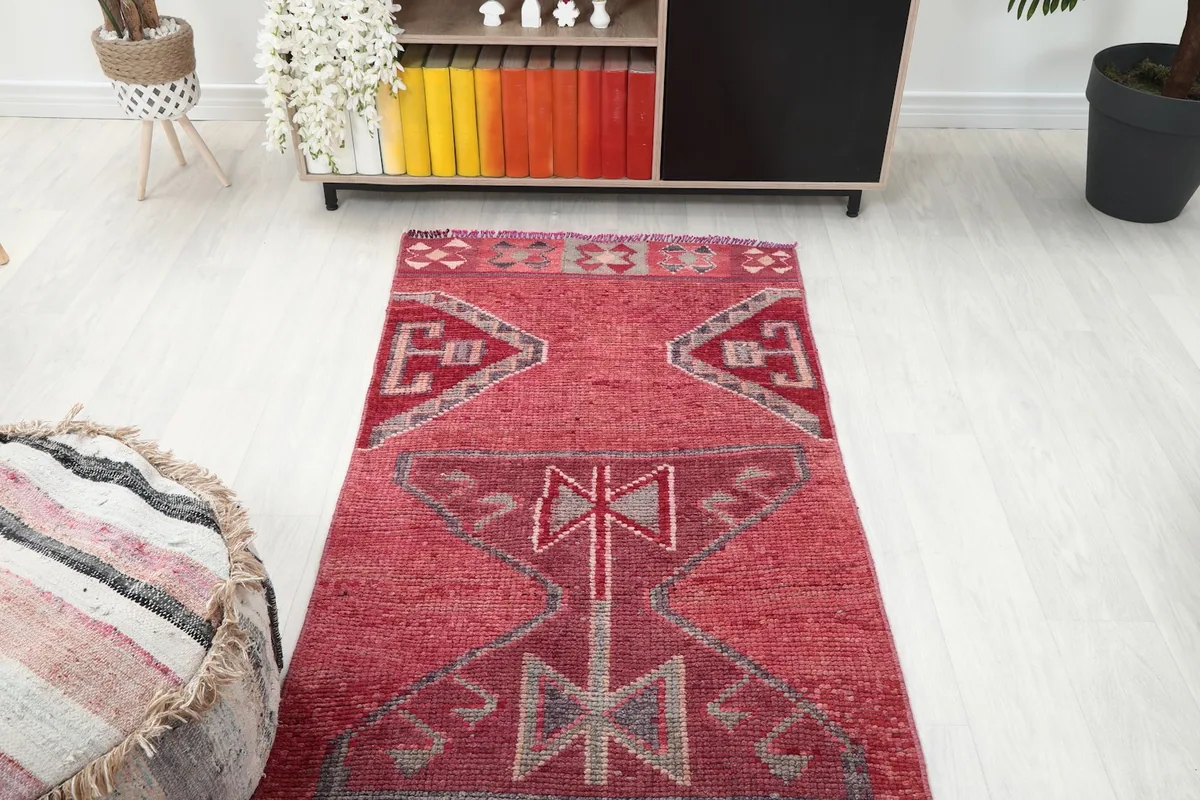 Overhead view of the Rose Tribal Anatolian runner rug in a room, looking towards a cabinet