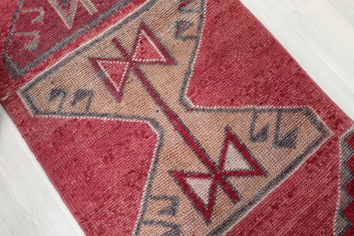 Close-up of a central tan and rose geometric motif within the runner's design