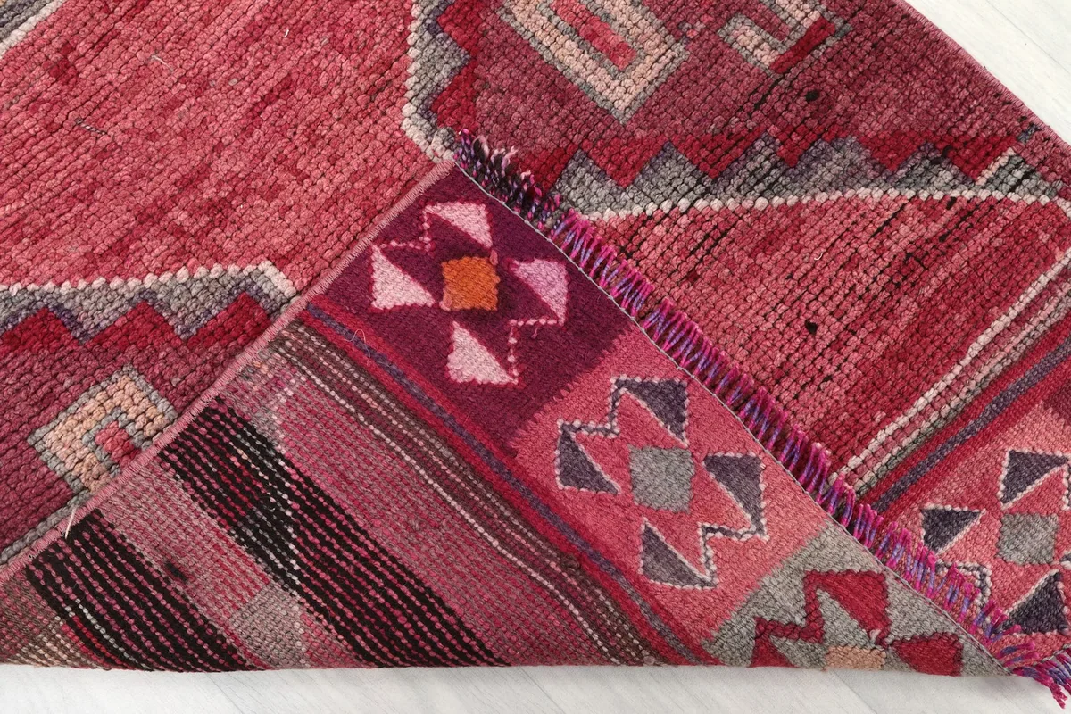 Folded corner of the rug revealing the cotton foundation and intricate backing