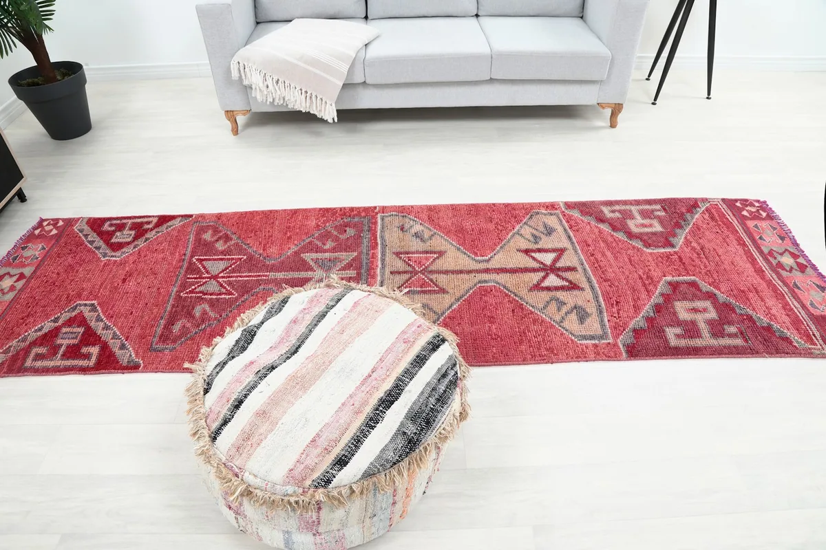 Full overhead view of the Rose Tribal Anatolian runner rug in a room with a sofa and pouf