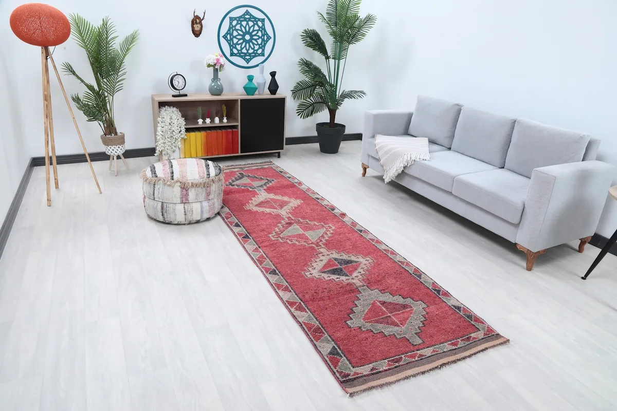 Angled view of the red runner rug in a room, showing its length and design alongside furniture