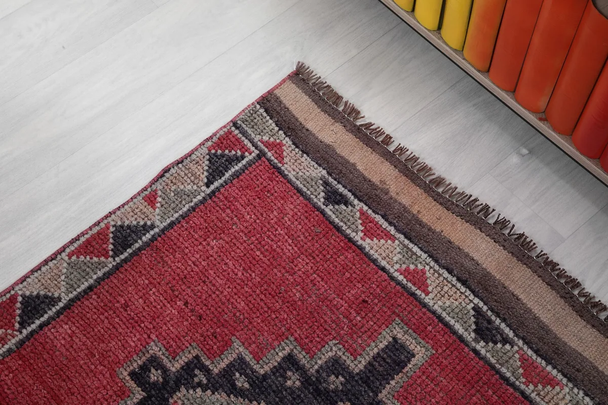 Close-up of the rug's edge, showing the woven border with triangle motifs and natural fringe