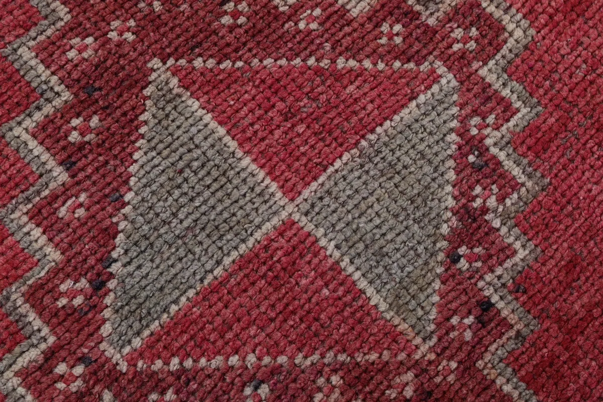 Extreme close-up showing the texture of the hand-knotted wool pile and intricate geometric weaving