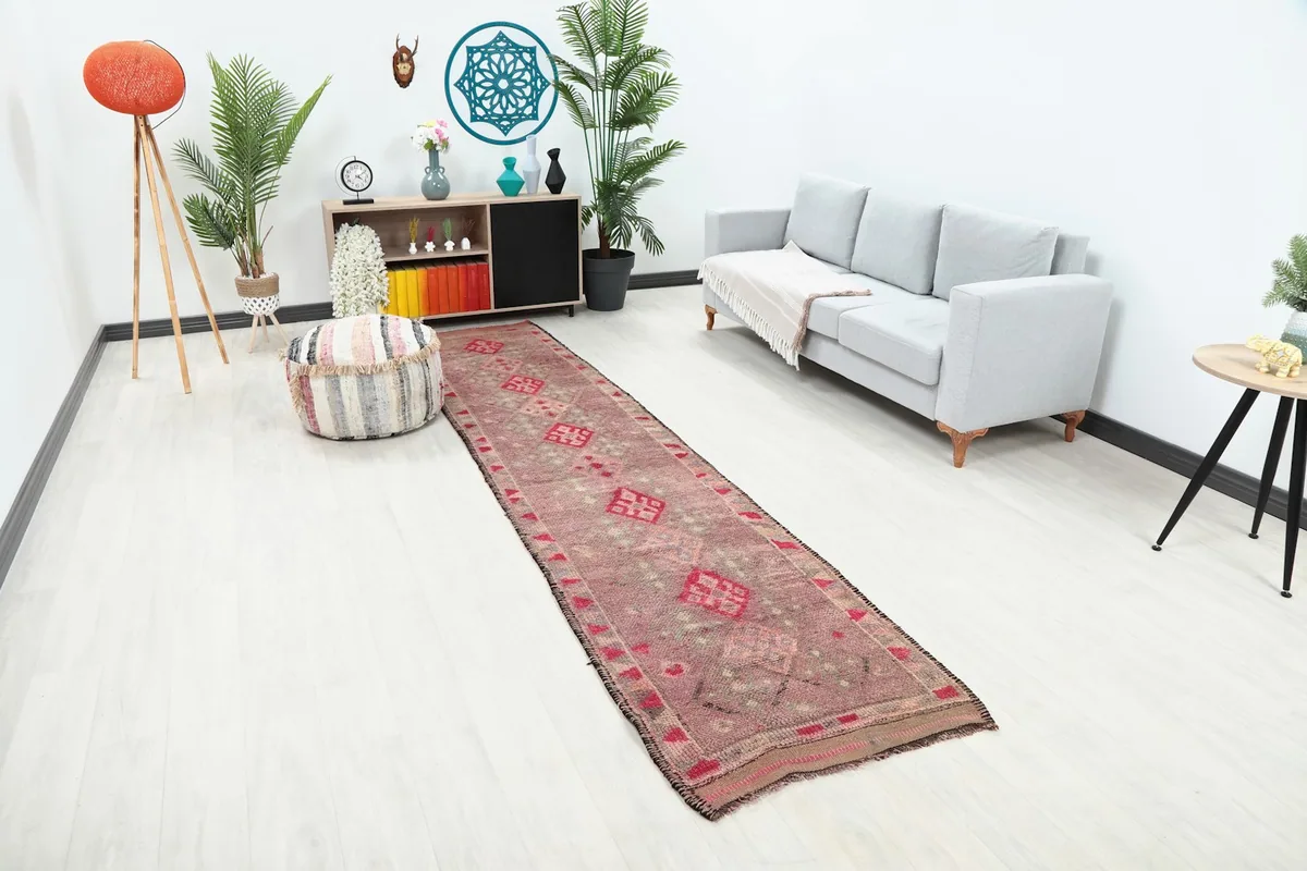 Long view of the rose and gray geometric runner in a room setting, showing its length