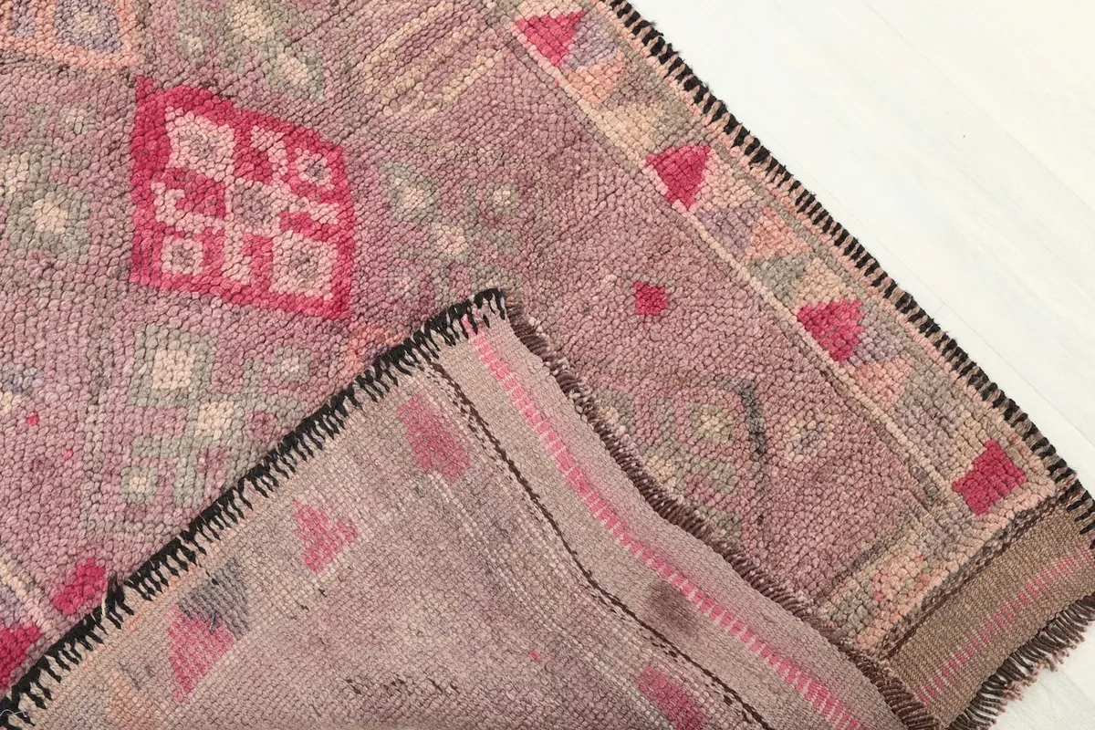 Corner of the runner folded to reveal the hand-knotted cotton foundation and reverse side