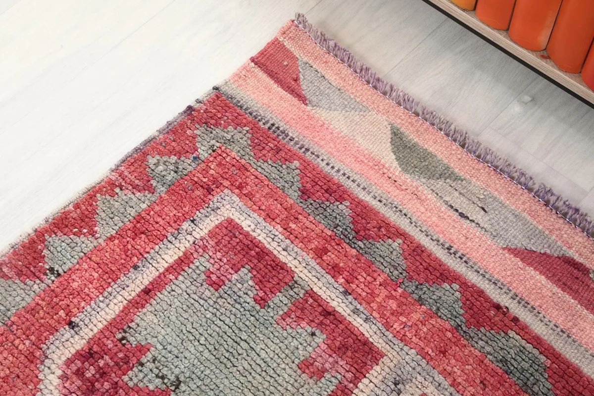 Close-up of the rug's border showing the subtle color variations and wear