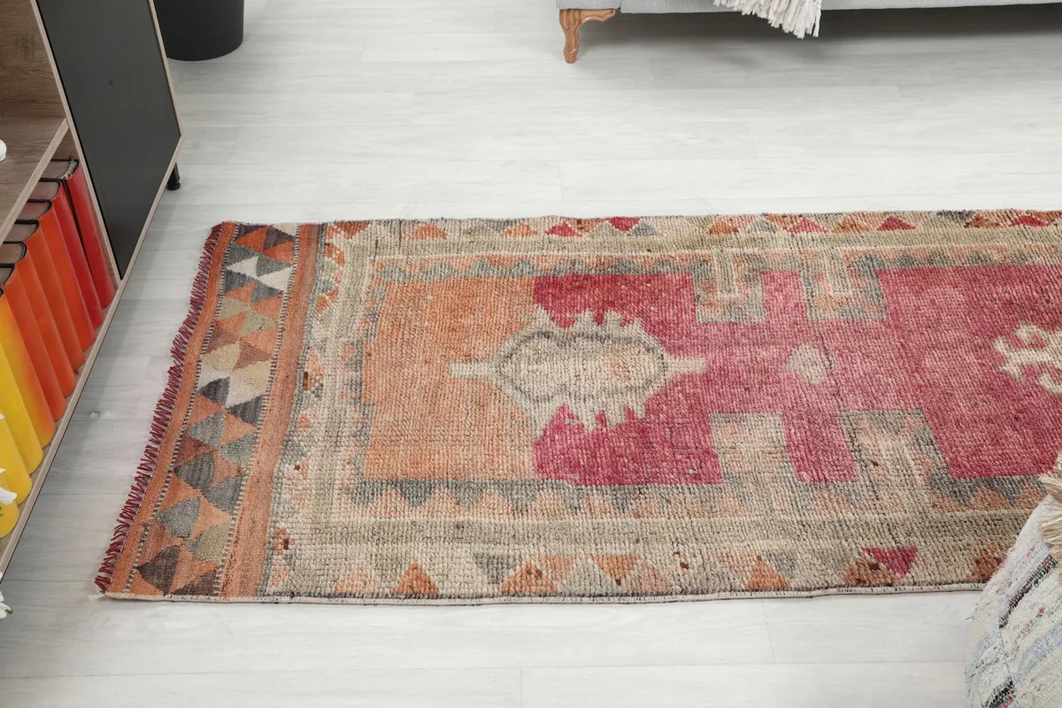 Angle view of the rug's end, showing the transition from the rose field to the border