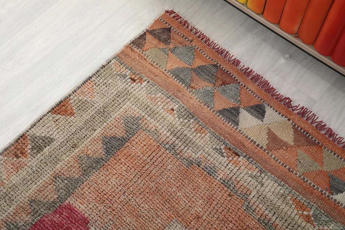 Detailed view of the rug's border with geometric triangle patterns in various colors
