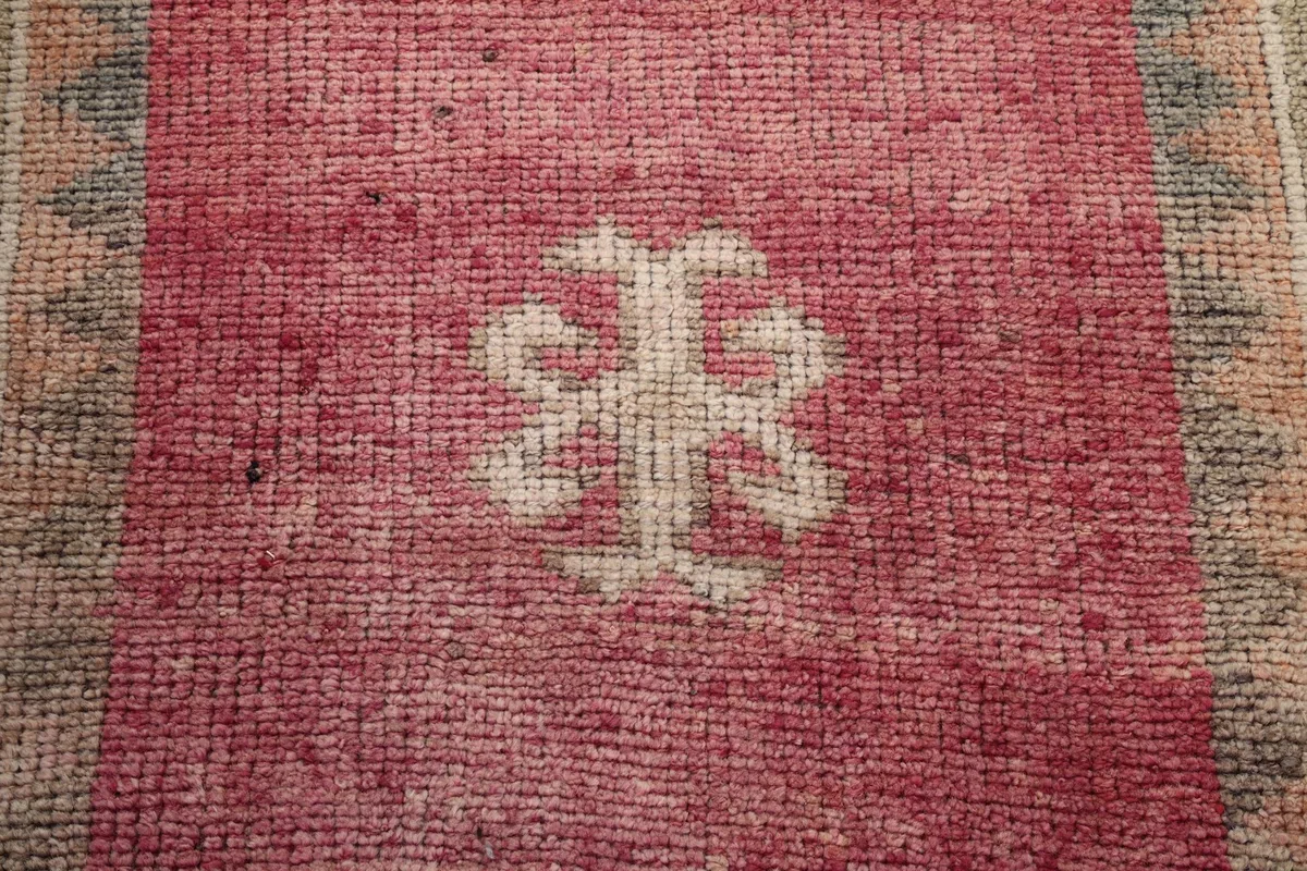 Extreme close-up showing the low wool pile and hand-knotted texture of the rug