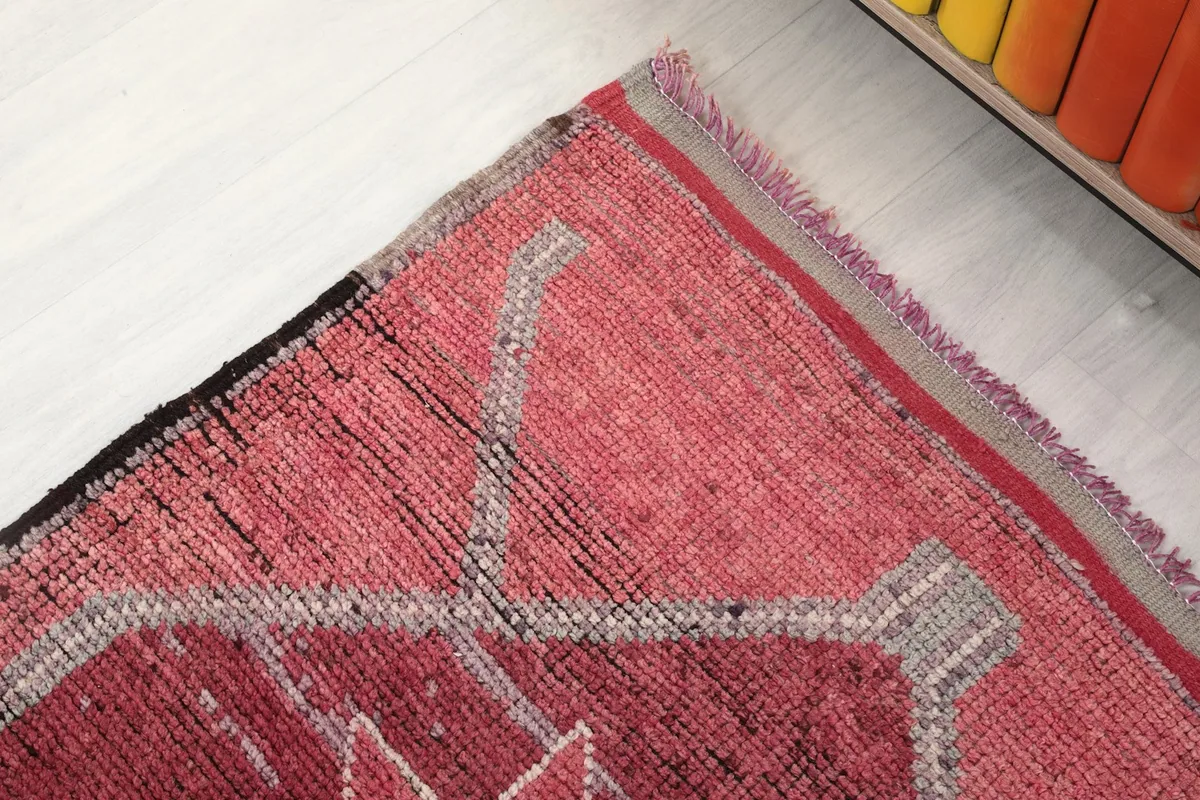 Corner detail of the rose runner rug showing the border and fringe