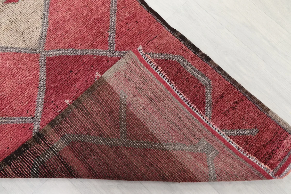 Underside view of the hand-knotted rose runner rug, showing the cotton foundation