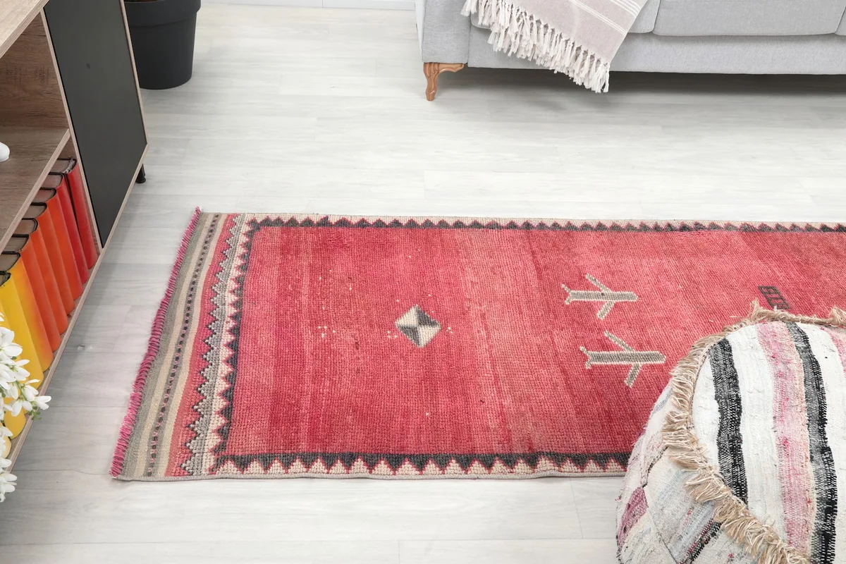 View of the runner rug from above, showing its placement in a room with a sofa and a decorative ottoman.