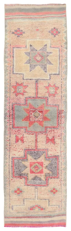 Full overhead view of the beige and rose vintage Anatolian runner rug on a white background