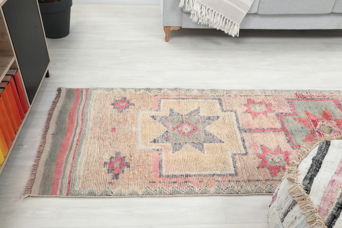 Wide angle view of the beige and rose runner rug extending from a seating area in a home setting