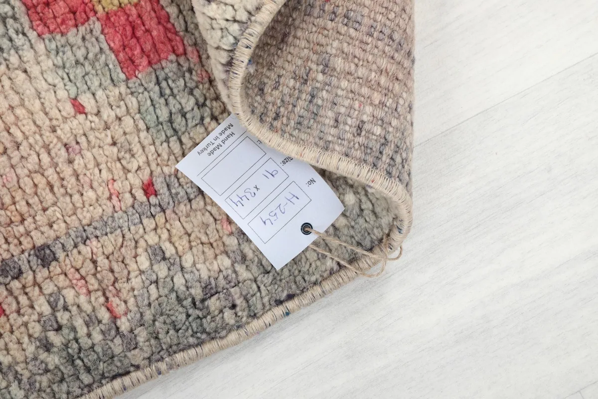 Close-up of the rug's low wool pile and a product tag, indicating its vintage quality
