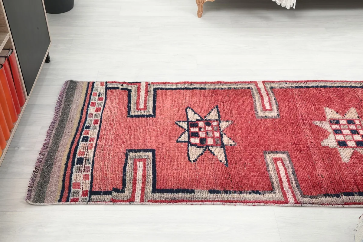 Long angle view of the red runner rug, showing multiple geometric star motifs