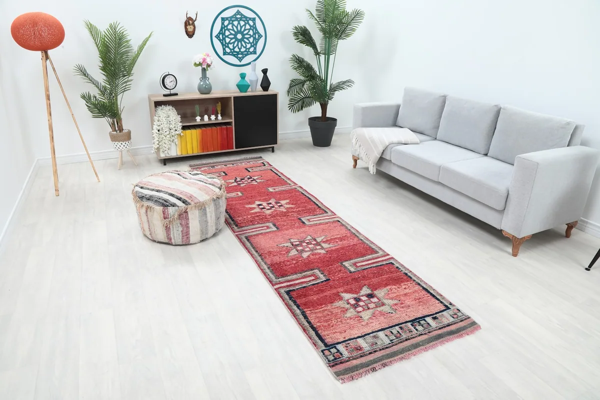 Angle view of the red geometric runner rug in a room, showing its length and design