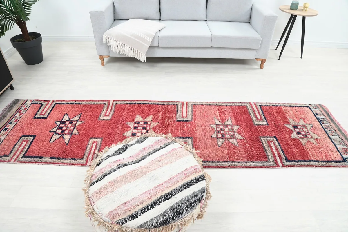 Room view from above, showing the red runner rug in relation to a sofa and ottoman