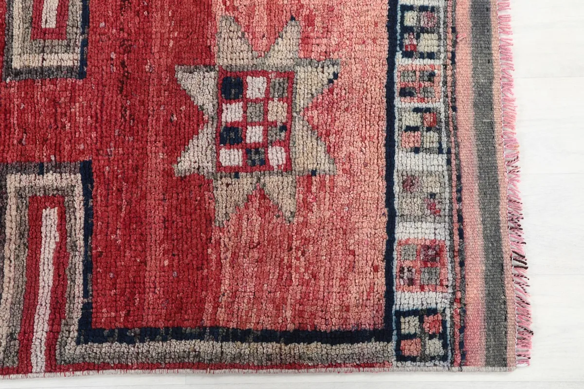 Detailed view of the red runner's field, showing a geometric star and border elements