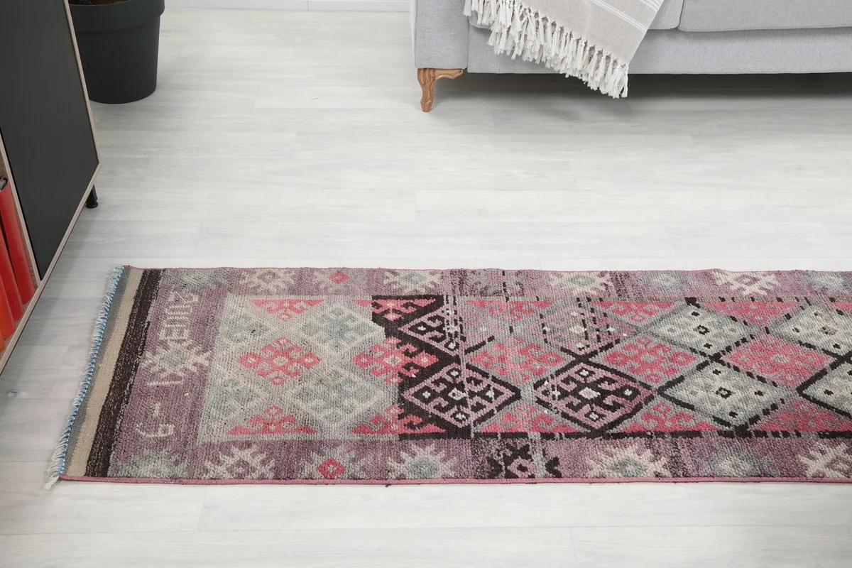 Long view of the runner rug laid out in the room, showing the transition of colors and patterns.
