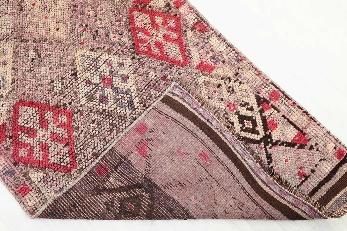 View of the back of the hand-knotted wool rug, showing the cotton foundation and knotting structure