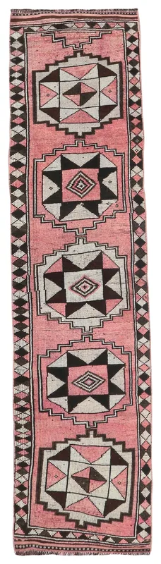 Full top view of the vintage Anatolian runner rug with pink, black, and cream geometric patterns