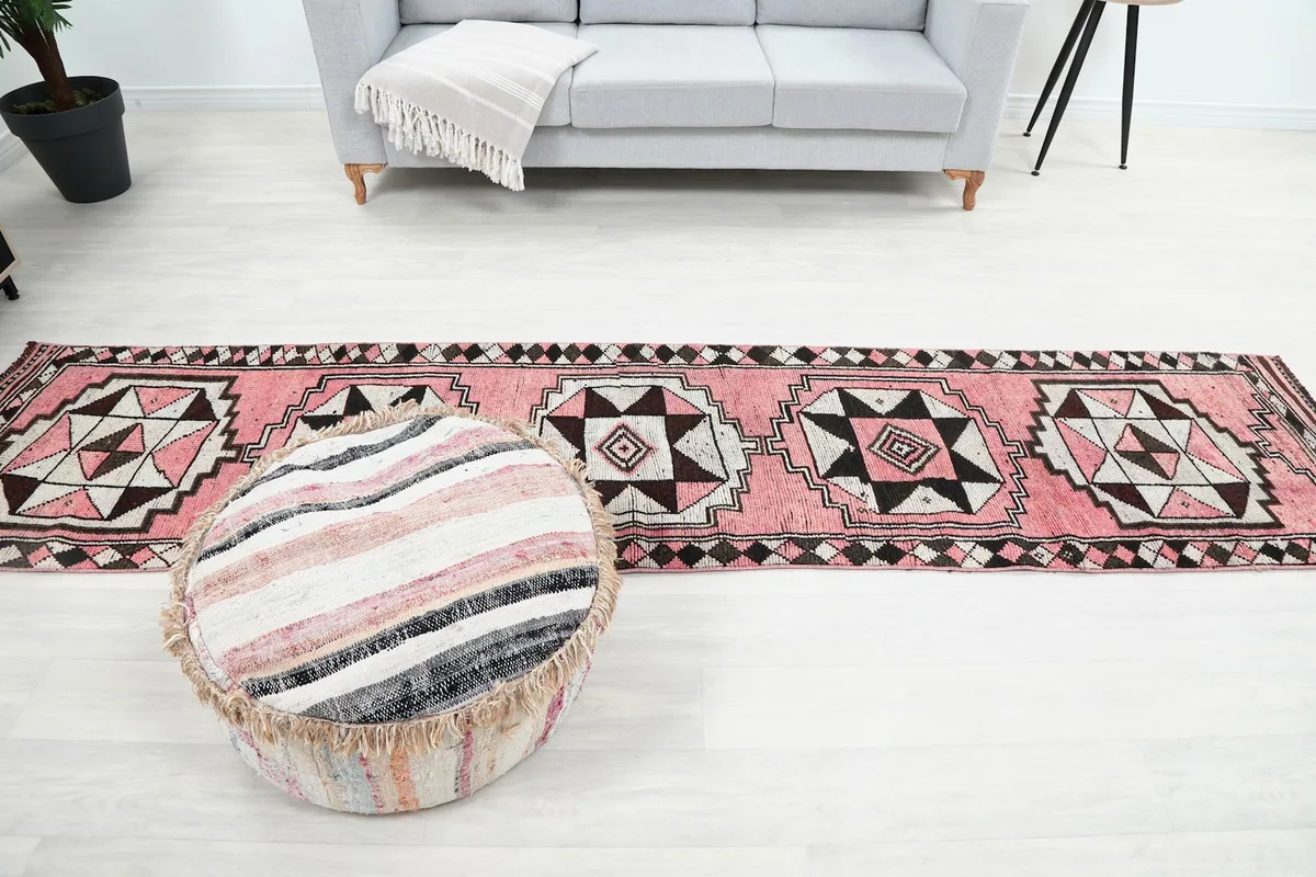Long shot of the pink geometric runner rug in a living space, showing its full length