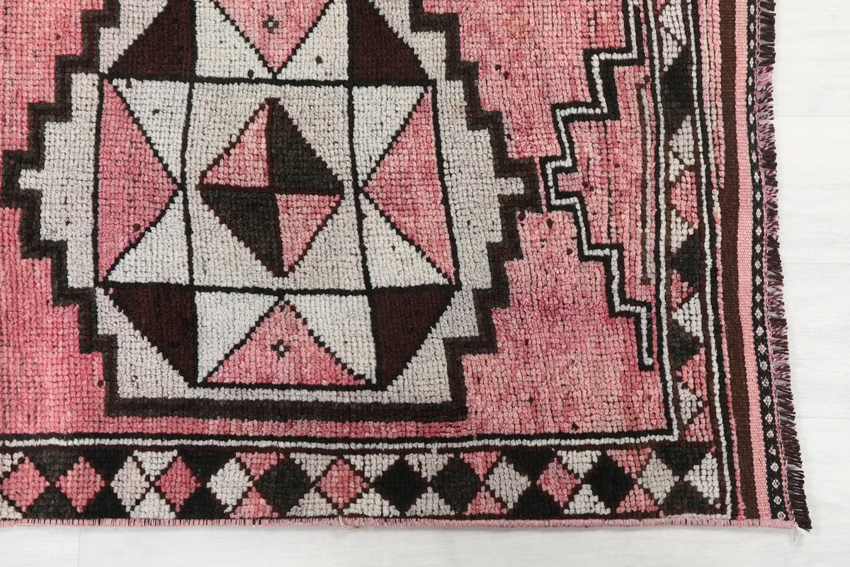 Detailed view of the rug's corner showing tribal geometric design and border