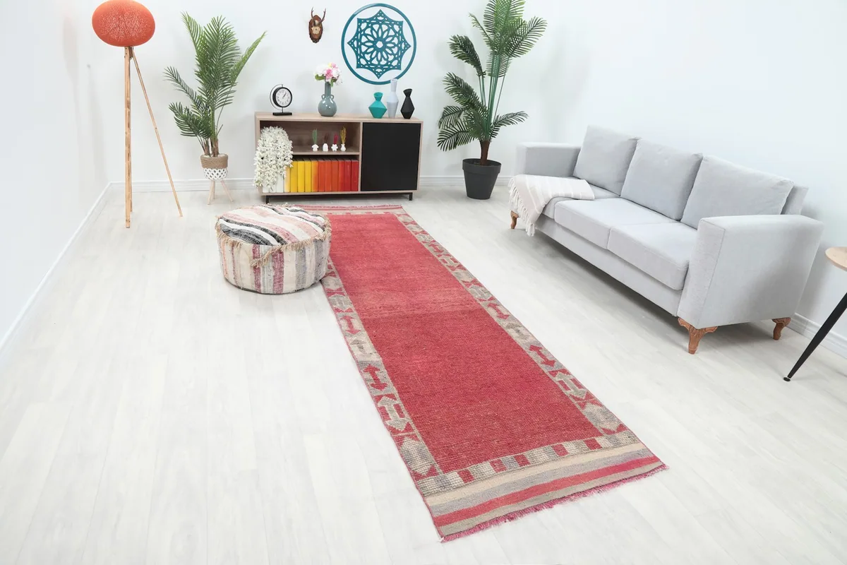 Overhead view of the rose runner in a room, highlighting its position next to a sofa and ottoman.