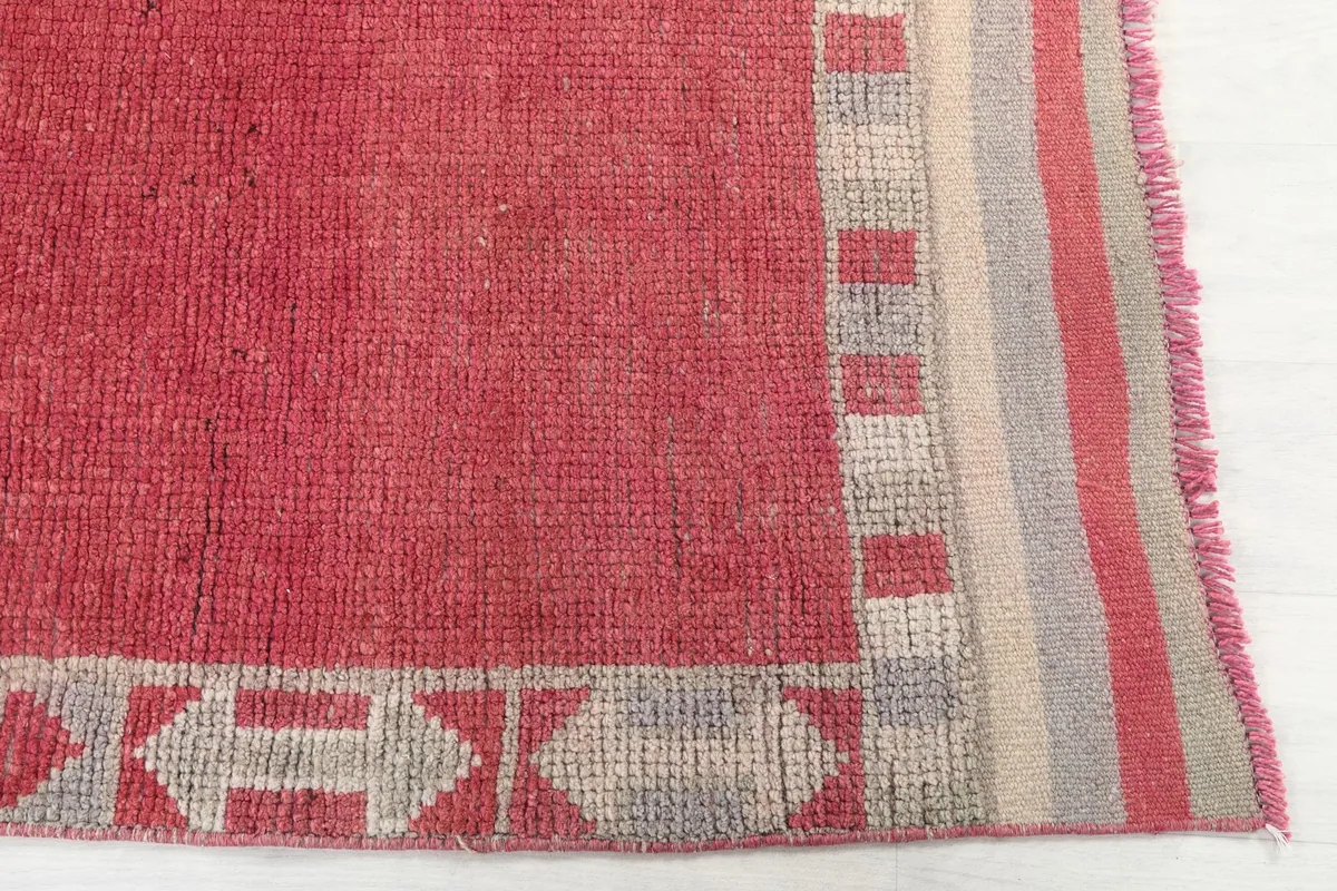 Detailed view of the runner's corner, showing the geometric patterns in beige and gray and the striped edge.