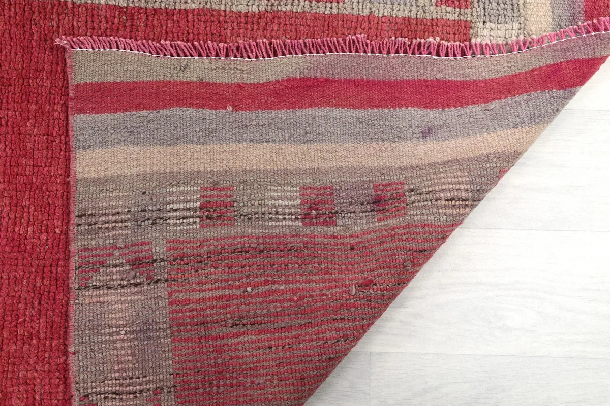 Close-up of the runner's back, revealing the hand-knotted construction and the striped pattern of the foundation.