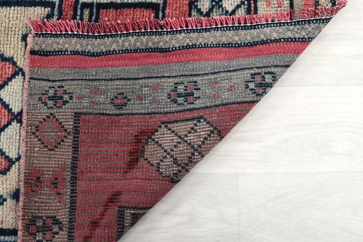 View of the rug's backing and the hand-knotted construction, with a folded edge