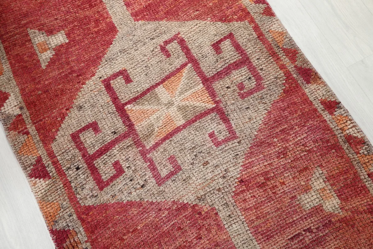 Close-up of a central geometric motif in rust, red, and tan colors