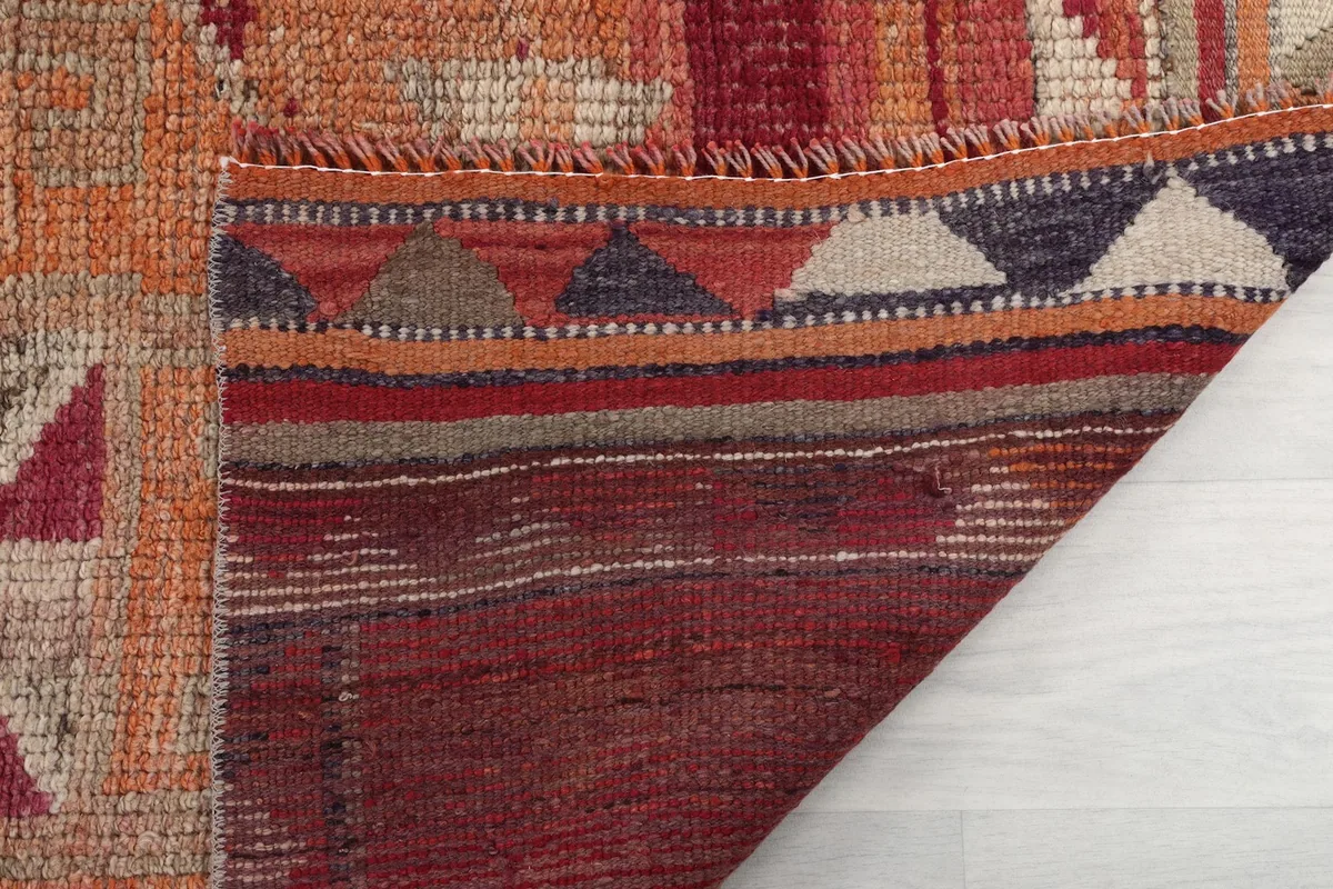 Close-up of the rug's back, revealing the hand-knotted structure and fringe