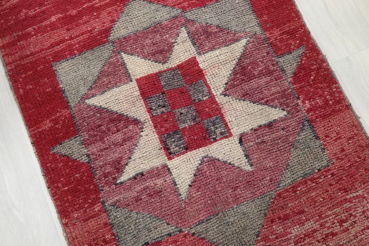 Close-up of a central geometric star motif with red and gray squares