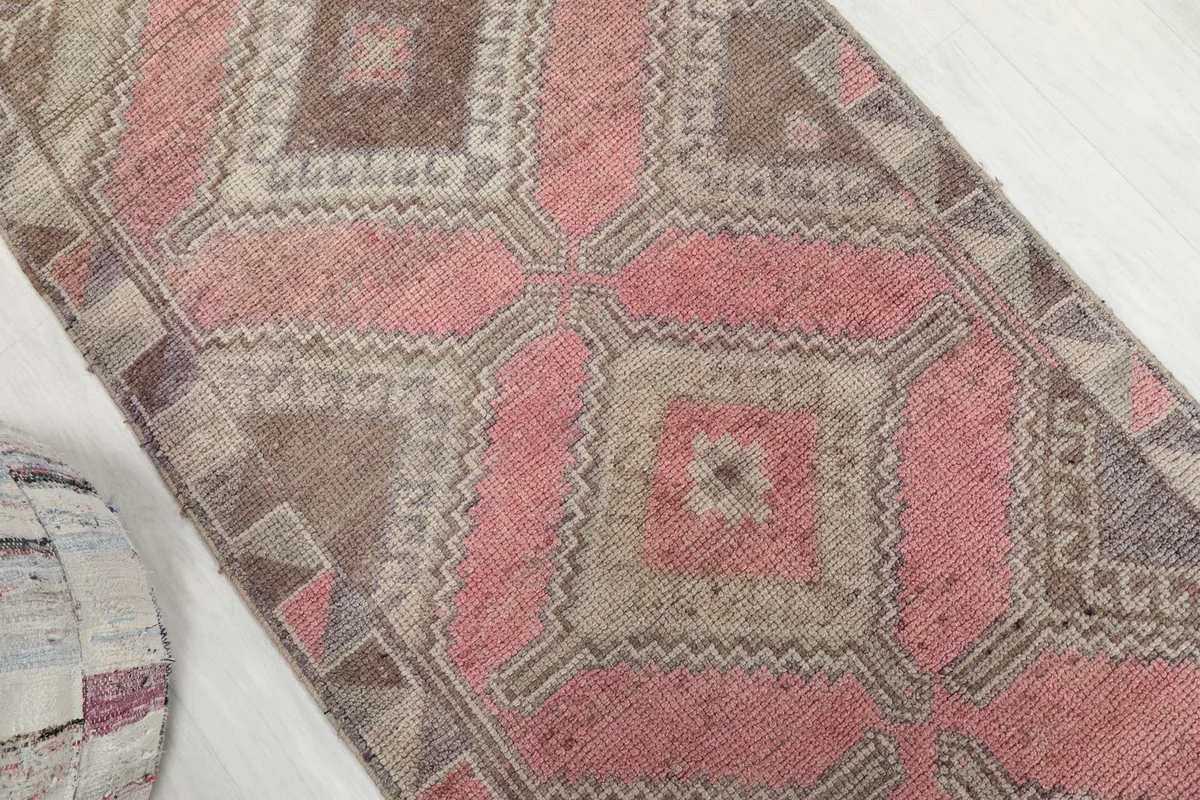 Overhead angled shot of the runner rug, focusing on the central rose and gray geometric medallion motifs.