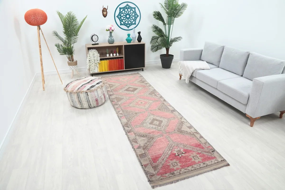 Long view of the rose and gray geometric runner rug extending through a hallway in a contemporary home.