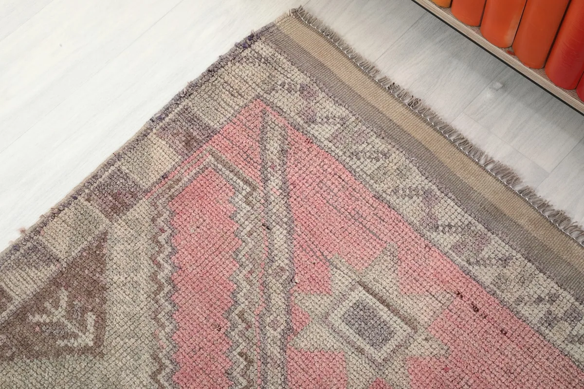 Corner detail of the runner rug, displaying the intricate gray and brown geometric border design.